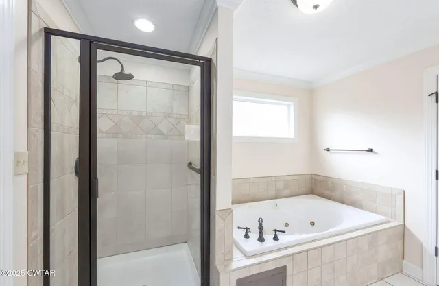 a bathroom with a tub a sink and a shower