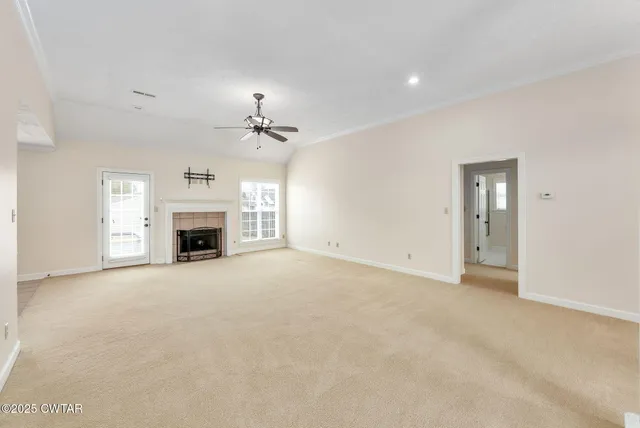 a view of empty room with a fireplace and a window