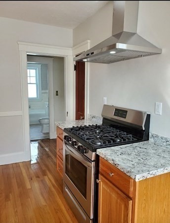 204 Eastern Avenue Lynn, MA 01902 - Photo 5 of 16 a kitchen with granite countertop a stove and a wooden floors