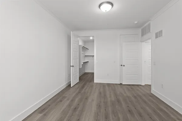 a view of an empty room with wooden floor