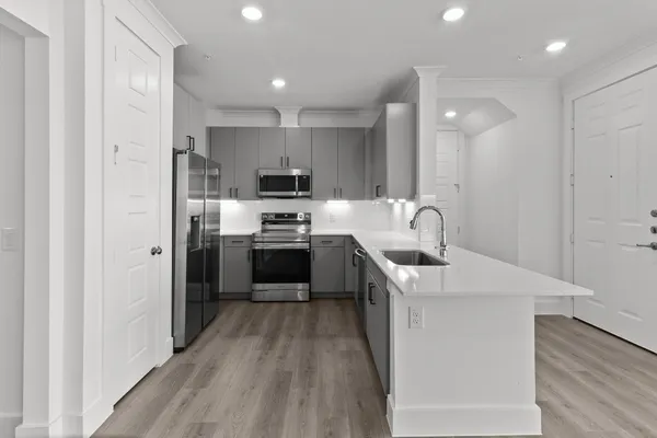 a kitchen with kitchen island a sink stainless steel appliances and cabinets