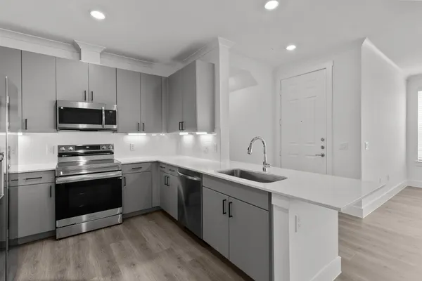 a kitchen with sink a microwave and cabinets