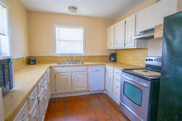 a kitchen with a sink stove and cabinets