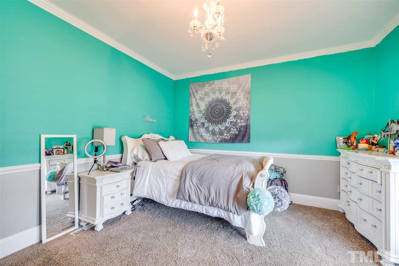 2256 Sanders Road Stem, NC 27581 - Photo 16 of 29 a bed room with a bed and a painting on the wall