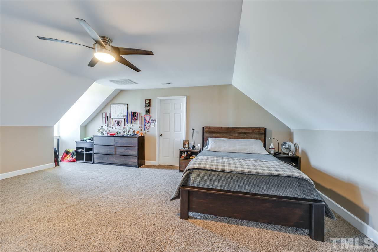 2256 Sanders Road Stem, NC 27581 - Photo 20 of 29 a bedroom with furniture and a chandelier
