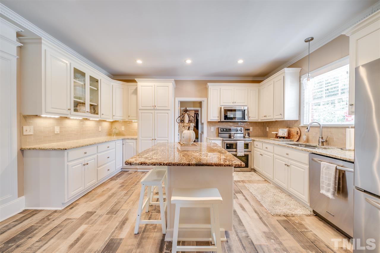 2256 Sanders Road Stem, NC 27581 - Photo 3 of 29 a large kitchen with granite countertop lots of counter space wooden floor and stainless steel appliances