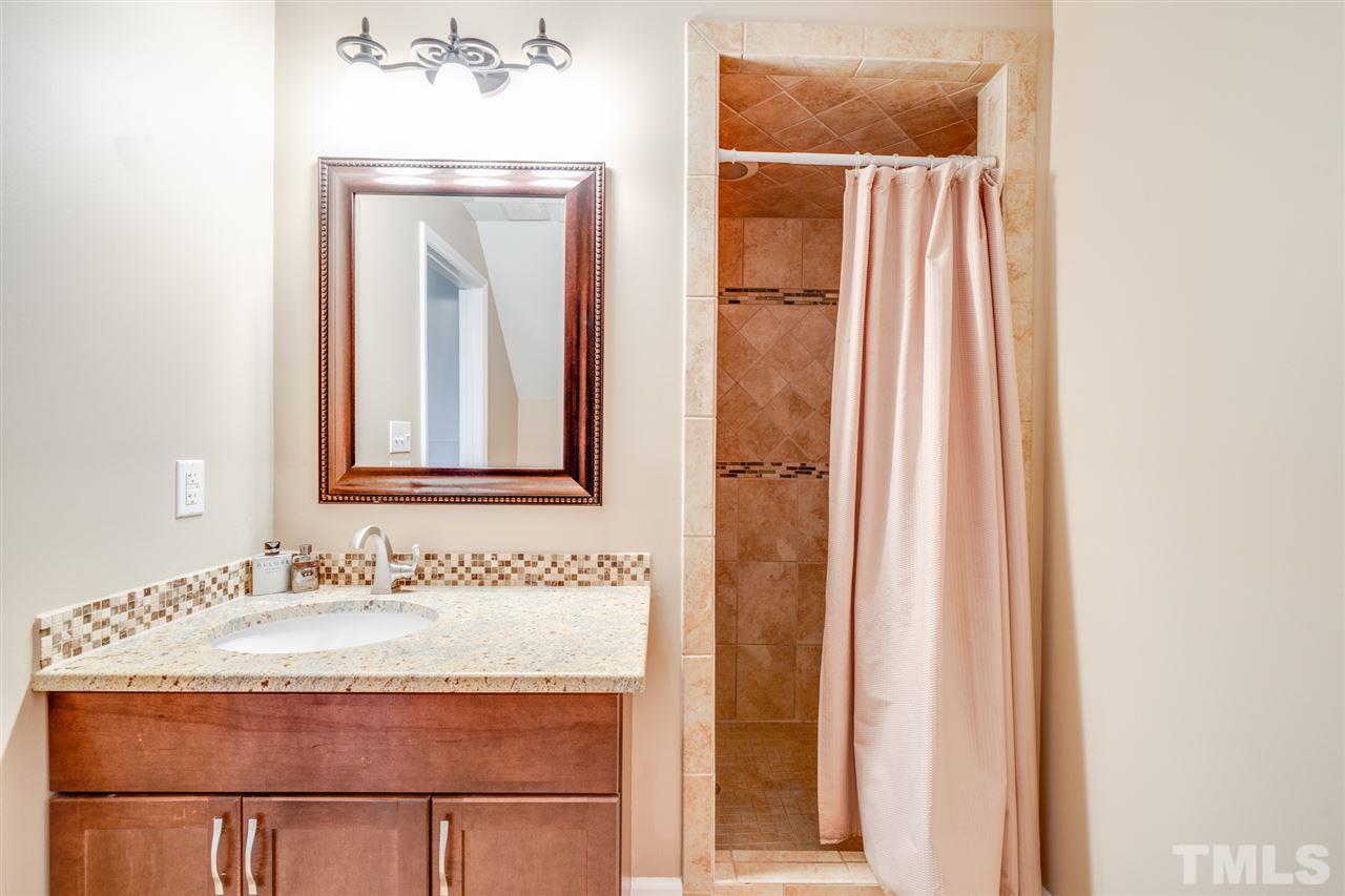 2256 Sanders Road Stem, NC 27581 - Photo 21 of 29 a bathroom with a granite countertop sink and a mirror