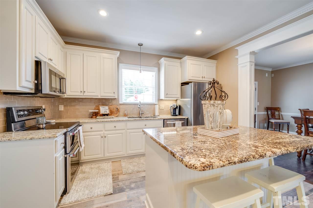 2256 Sanders Road Stem, NC 27581 - Photo 4 of 29 a kitchen with kitchen island granite countertop a sink stove and refrigerator
