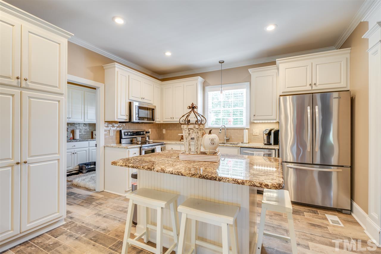 2256 Sanders Road Stem, NC 27581 - Photo 5 of 29 a kitchen with stainless steel appliances granite countertop a refrigerator stove microwave and sink