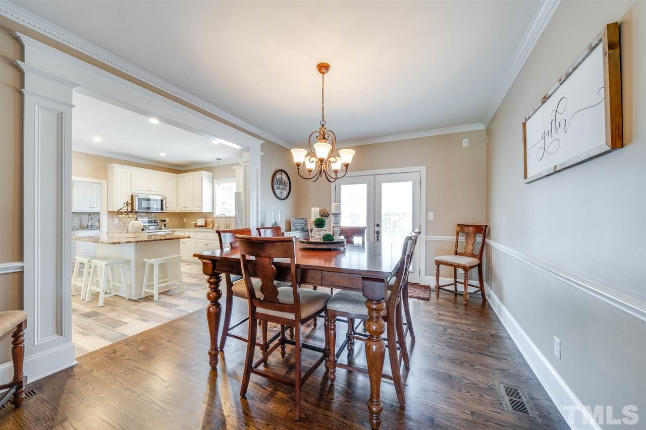 2256 Sanders Road Stem, NC 27581 - Photo 6 of 29 a view of a dining room and livingroom with furniture wooden floor a chandelier