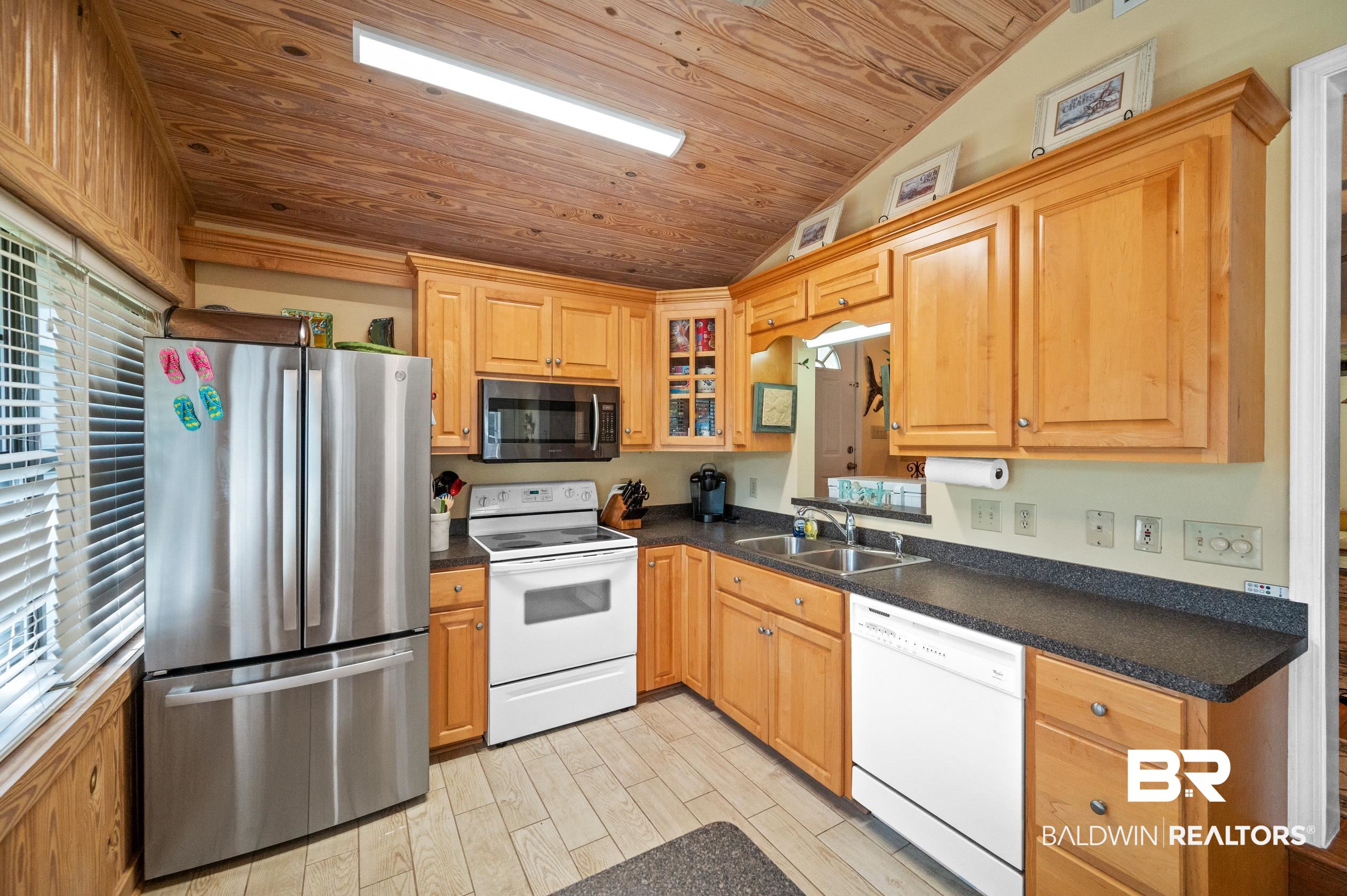 5392 Ornacor Avenue Orange Beach, AL 36561 - Photo 11 of 48 Kitchen featuring sink, light hardwood / wood-style flooring, wooden ceiling, vaulted ceiling, and stainless steel appliances