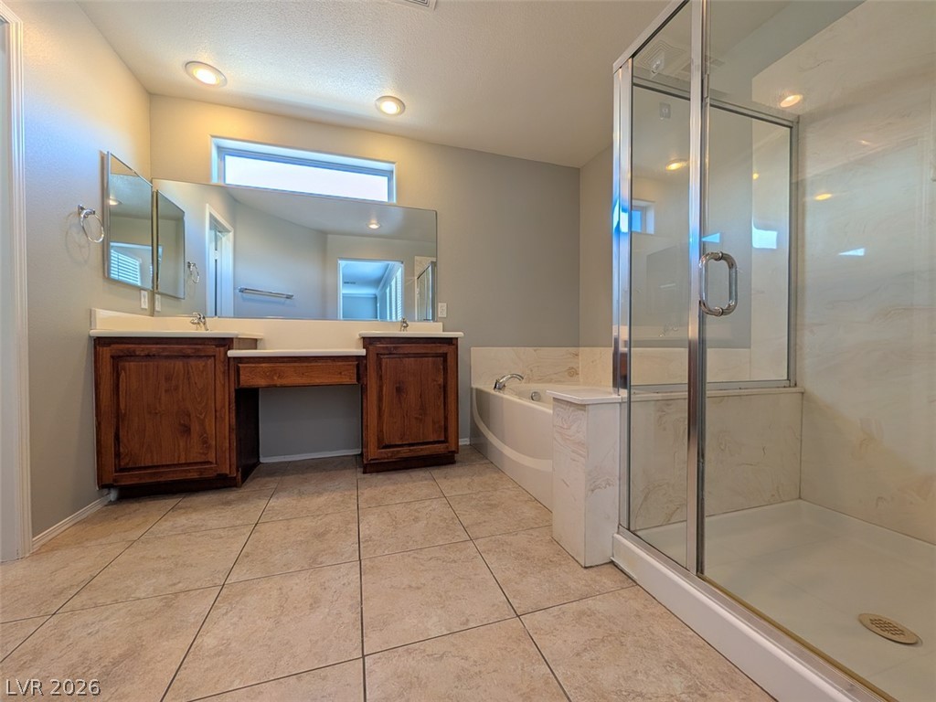 10308 Faustine Avenue Las Vegas, NV 89129 - Photo 12 of 28 Dual vanities and a soaking tub create a personal spa retreat.