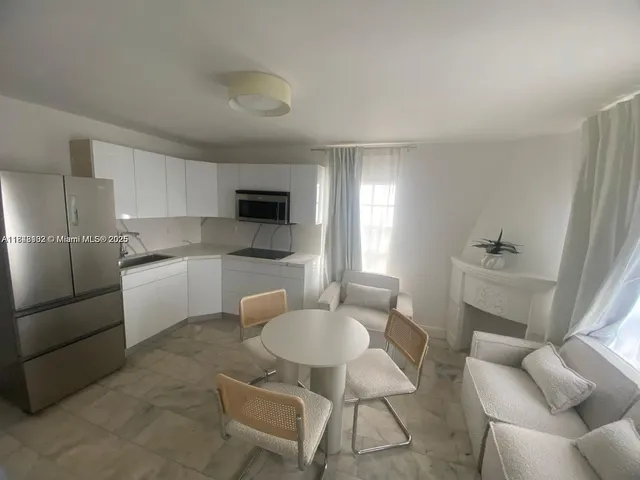 a kitchen with stainless steel appliances kitchen island granite countertop a sink and a refrigerator