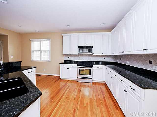 420 Third Baxter Street Fort Mill, SC 29708 - Photo 7 of 16 a kitchen with granite countertop wooden floors appliances and sink