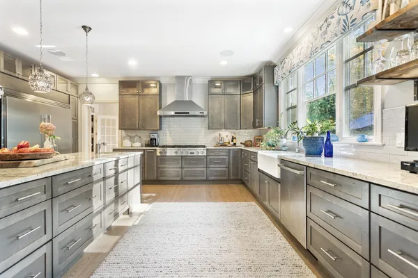 a kitchen with kitchen island granite countertop lots of white cabinets and stainless steel appliances