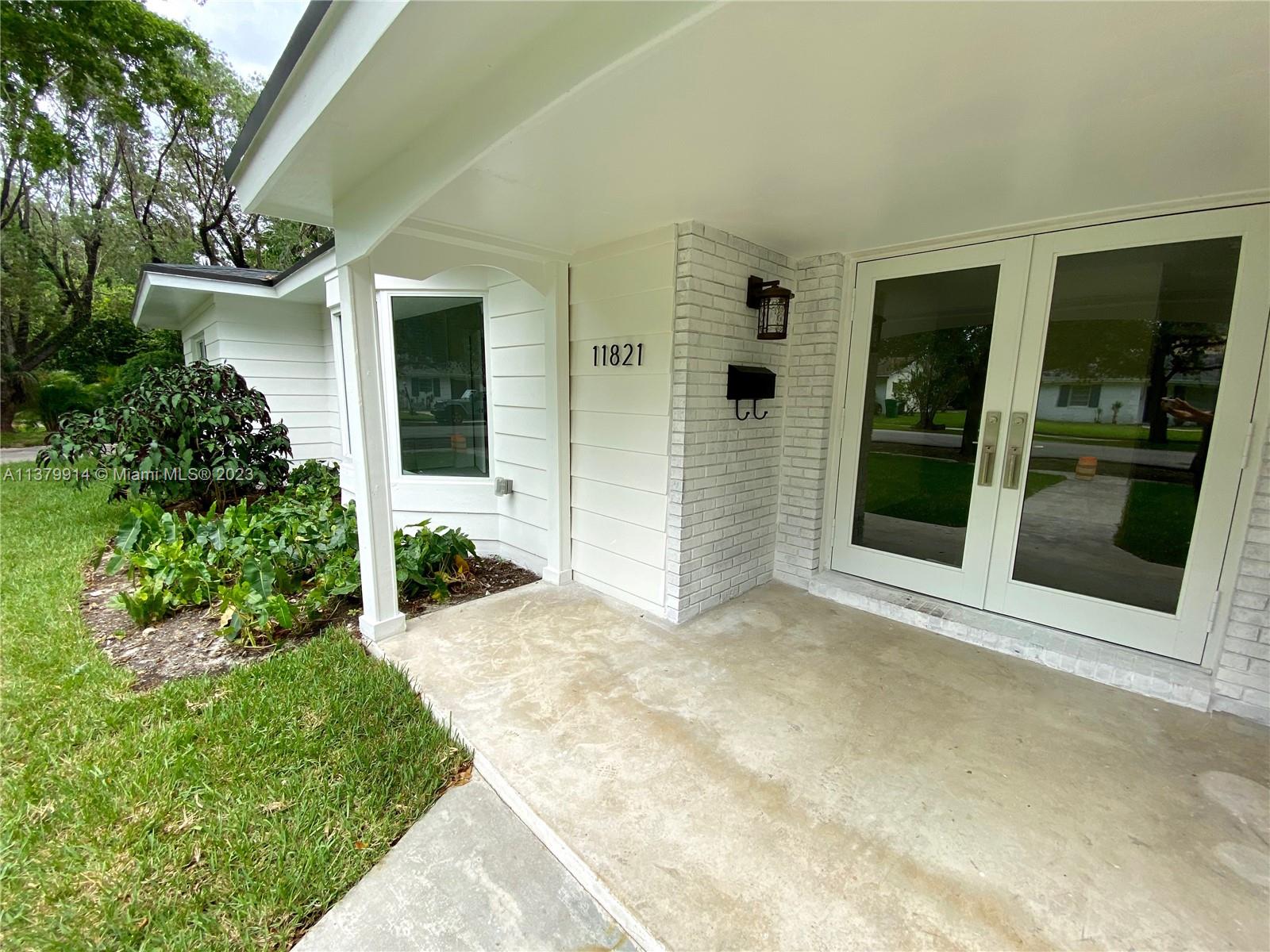 11821 Southwest 81st Road, Unit 11821 Pinecrest, FL 33156 - Photo 13 of 14 front view of a house with a yard
