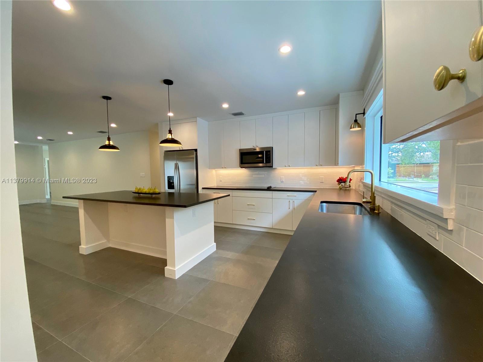 11821 Southwest 81st Road, Unit 11821 Pinecrest, FL 33156 - Photo 6 of 14 a large white kitchen with a large window