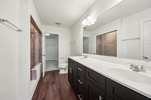 a spacious bathroom with a double vanity sink and a mirror