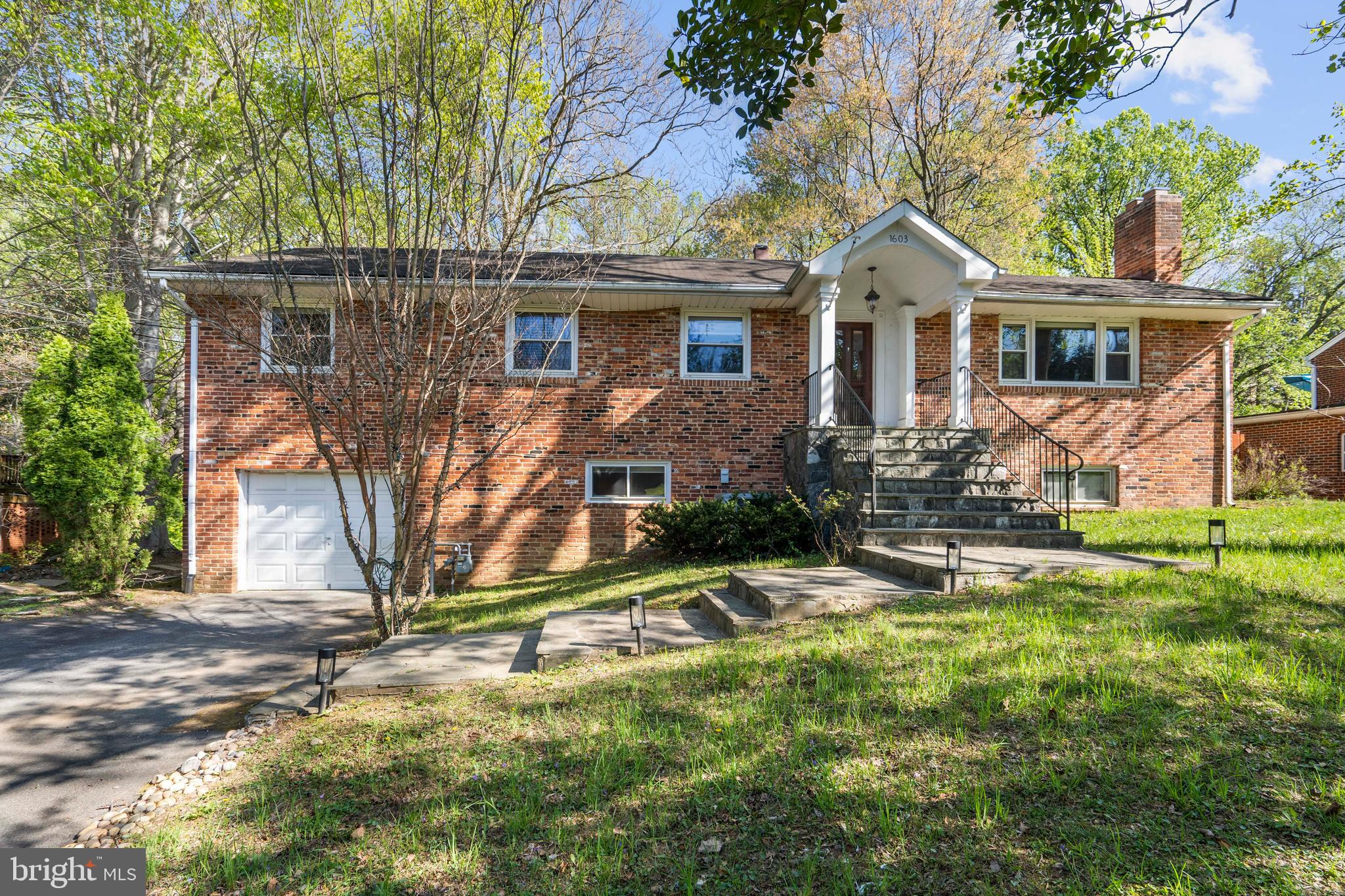a view of a yard in front of a house with large tree