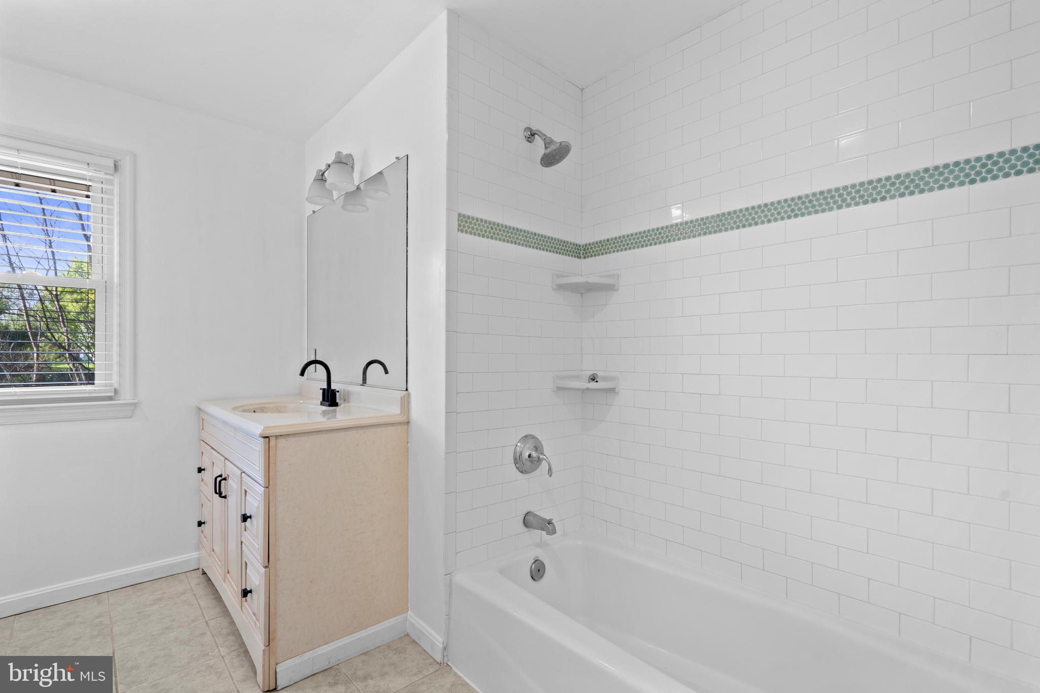 1603 Kirby Road McLean, VA 22101 - Photo 20 of 38 a bathroom with a bathtub a sink a window and a shower