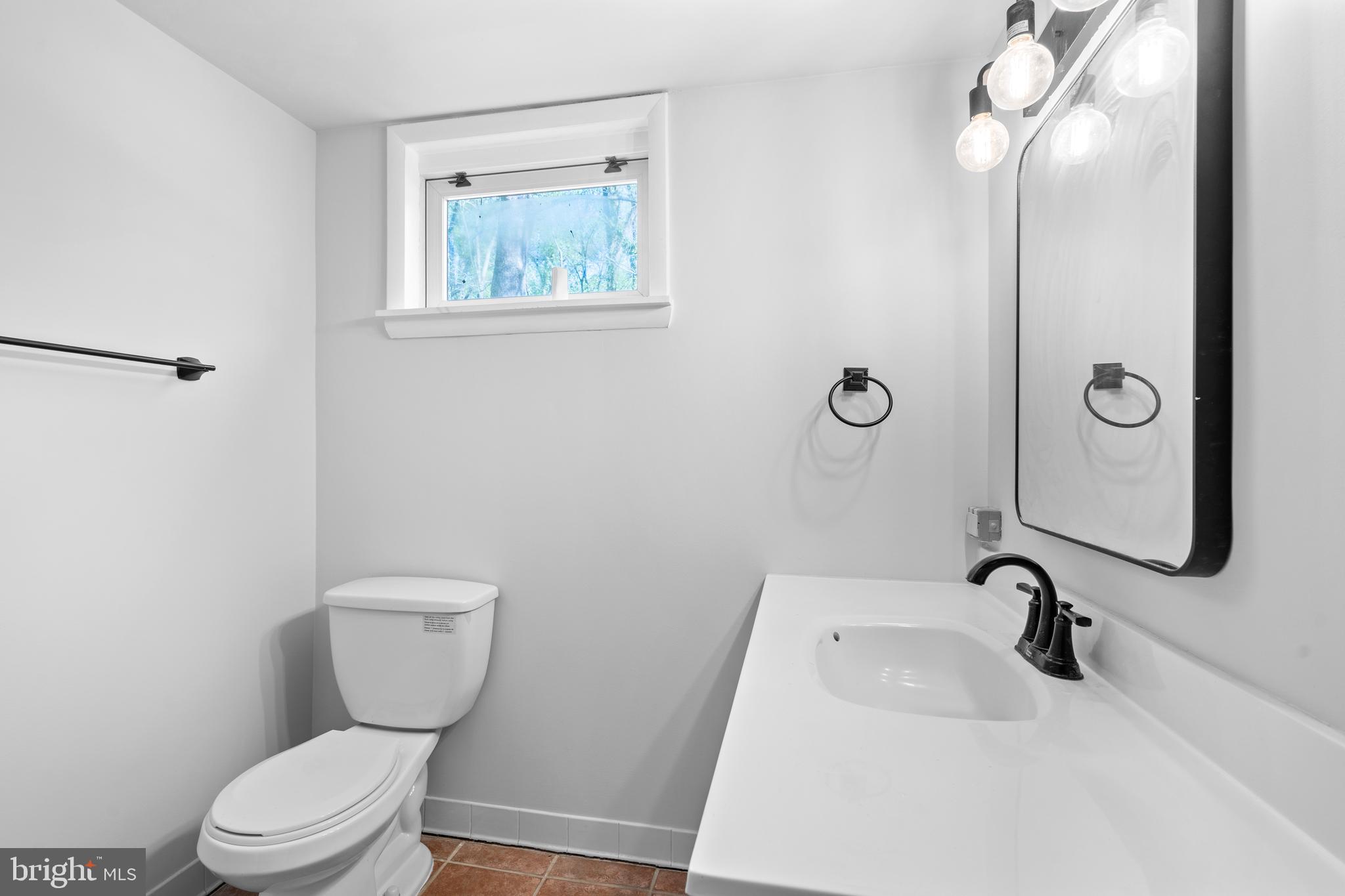 1603 Kirby Road McLean, VA 22101 - Photo 29 of 38 a bathroom with a toilet a sink and mirror