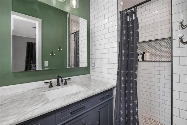 a bathroom with a granite countertop sink and a mirror