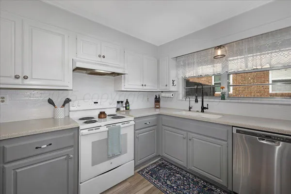 a kitchen with white cabinets sink and appliances