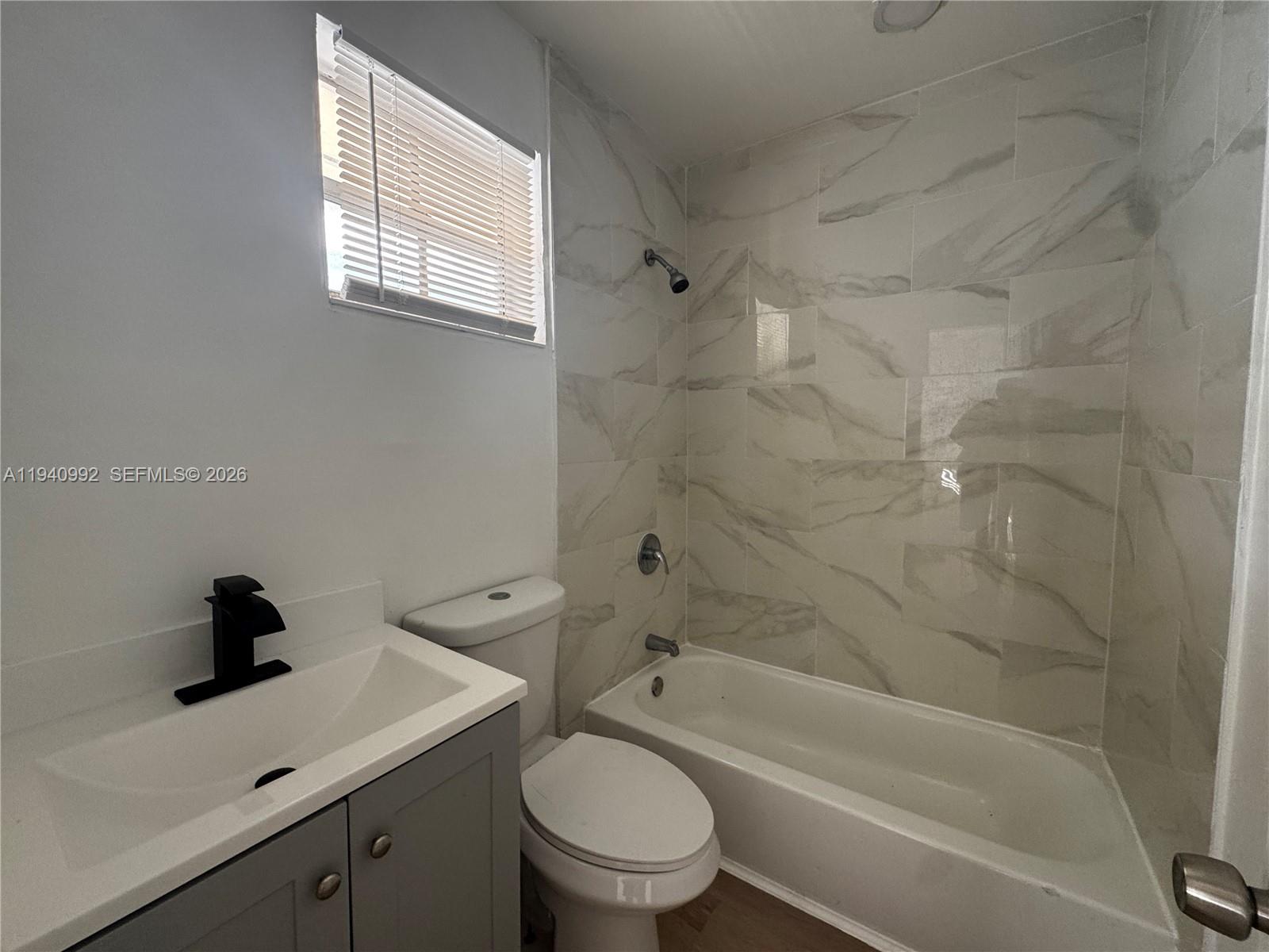 500 13th Street, Unit 10 Miami Beach, FL 33139 - Photo 1 of 12 a bathroom with a toilet sink a mirror a bathtub and vanity