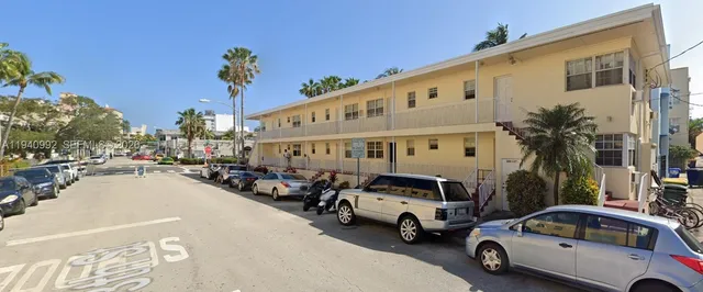 a view of a cars park in front of a building