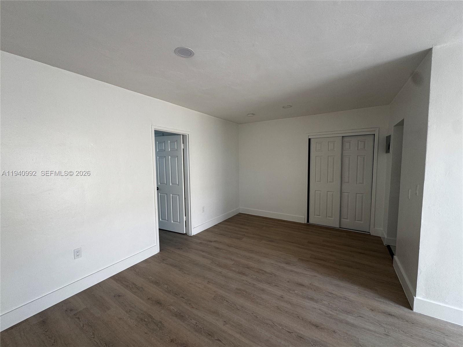500 13th Street, Unit 10 Miami Beach, FL 33139 - Photo 5 of 12 a view of an empty room with wooden floor and closet