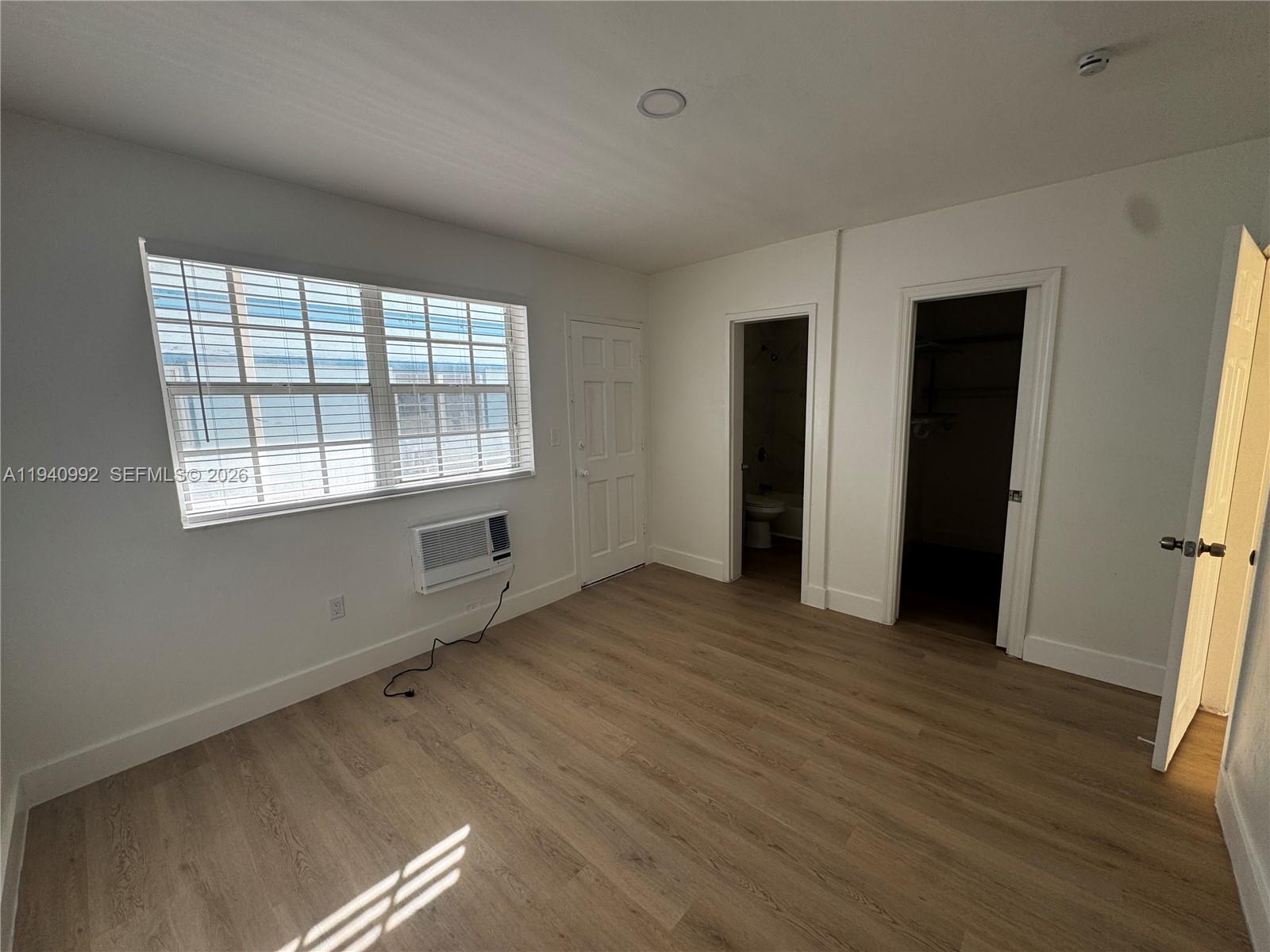 500 13th Street, Unit 10 Miami Beach, FL 33139 - Photo 10 of 12 a view of an empty room with wooden floor and a window