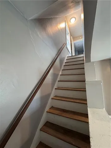 a view of a hallway with wooden floor and closet