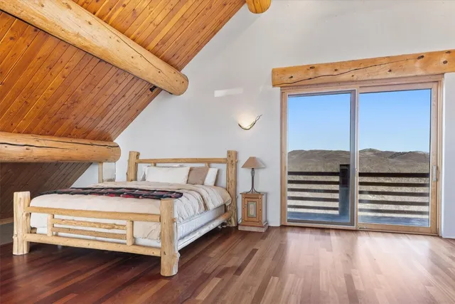 a view of a bedroom with wooden floor and stairs