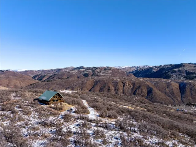 a view of a dry field with mountains in the background