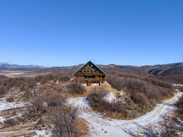 a view of a house with a mountain and a forest