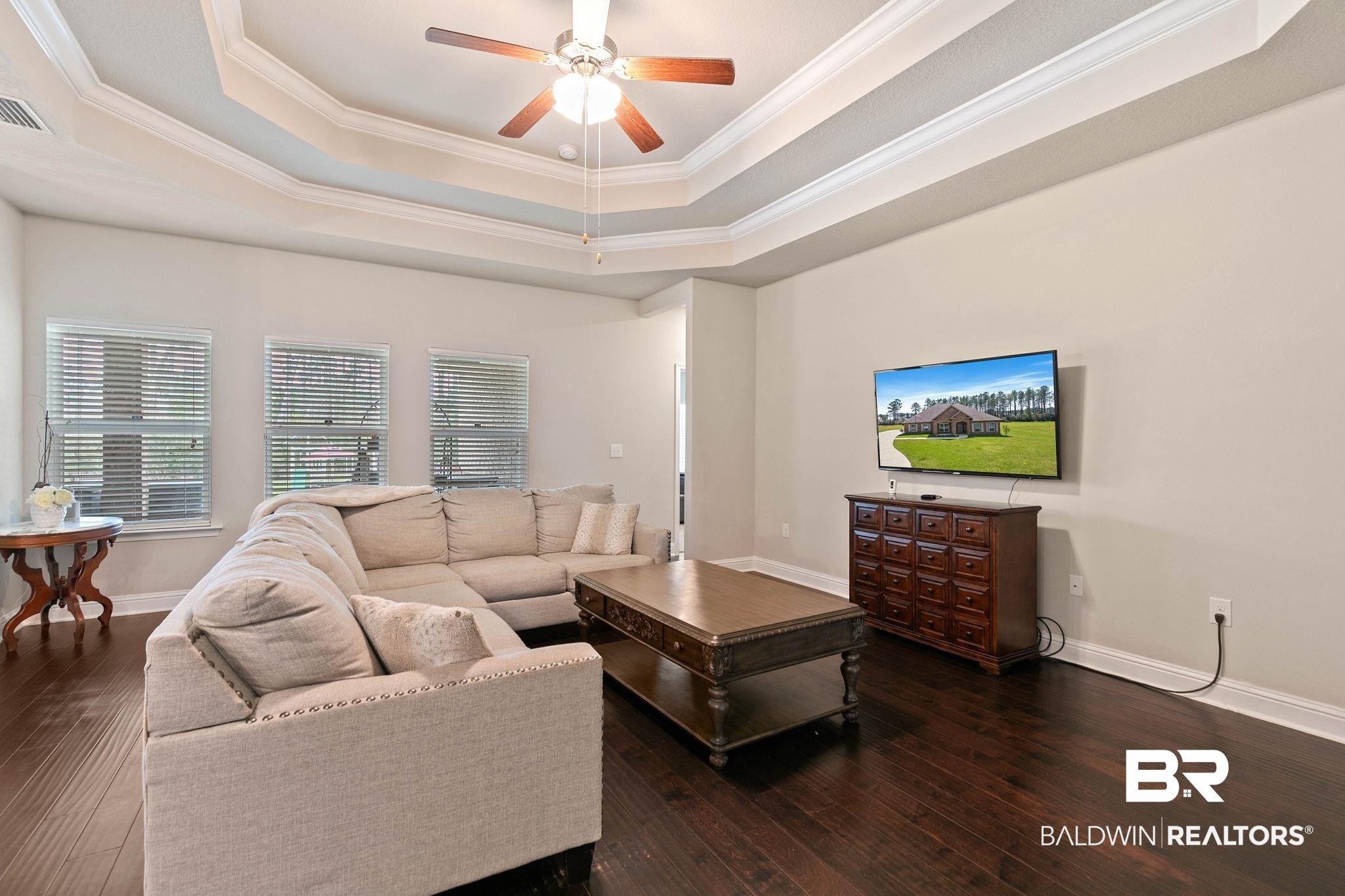 12750 B Jenkins Pit Road Daphne, AL 36527 - Photo 18 of 89 Living room with ceiling fan, dark wood-style floors, ornamental molding, and a raised ceiling