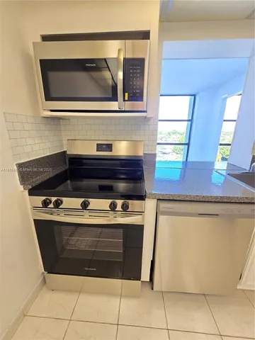 a kitchen with cabinets and a refrigerator