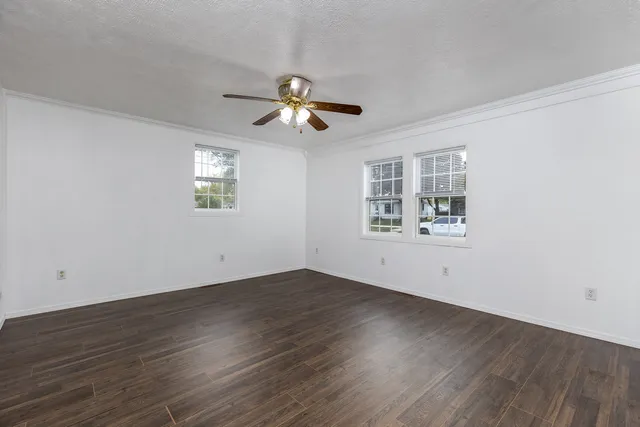 a view of empty room with wooden floor