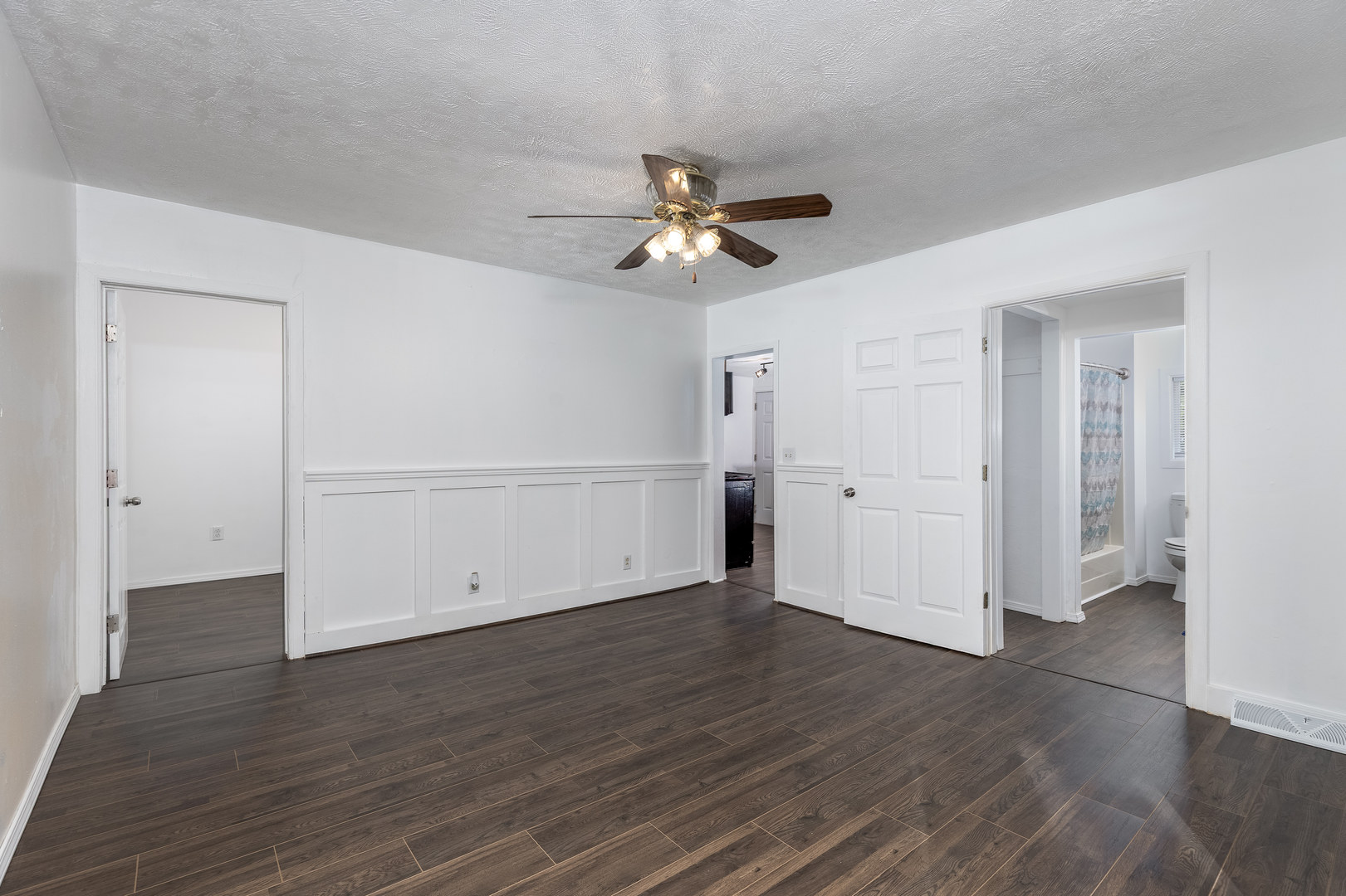 401 South 5th Avenue Streator, IL 61364 - Photo 7 of 17 an empty room with wooden floor a ceiling fan white walls and windows