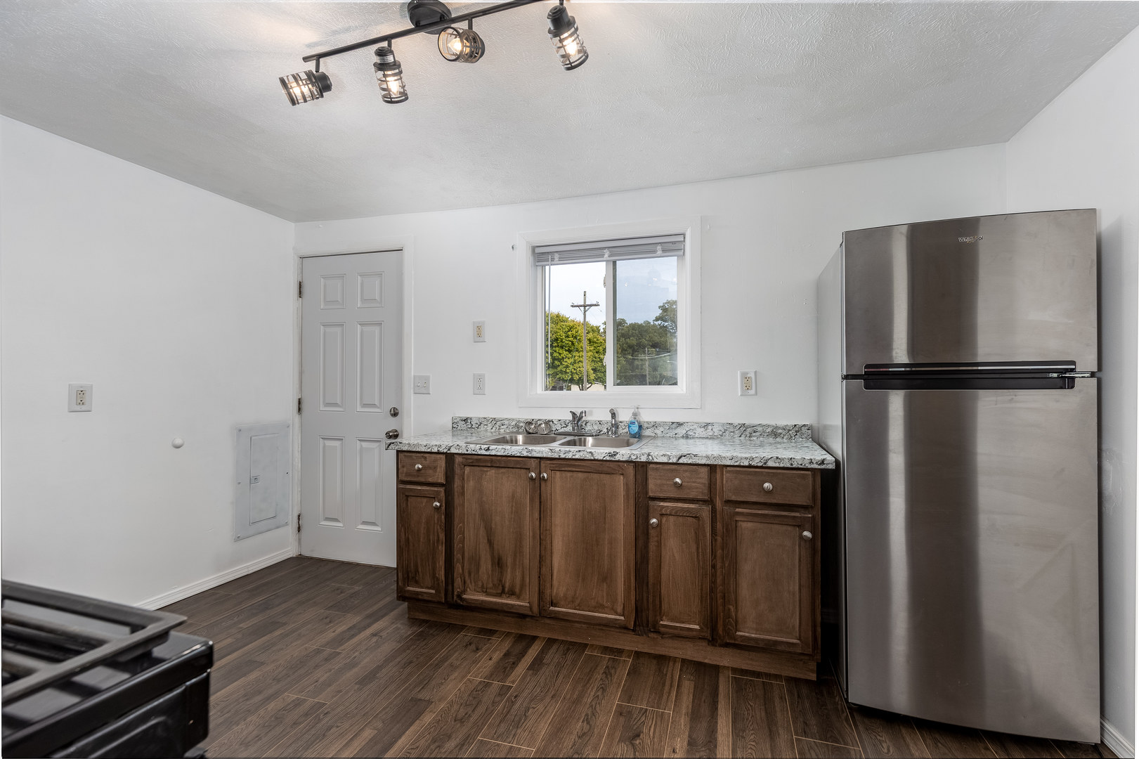 401 South 5th Avenue Streator, IL 61364 - Photo 8 of 17 a kitchen with granite countertop a refrigerator a sink and wooden cabinets