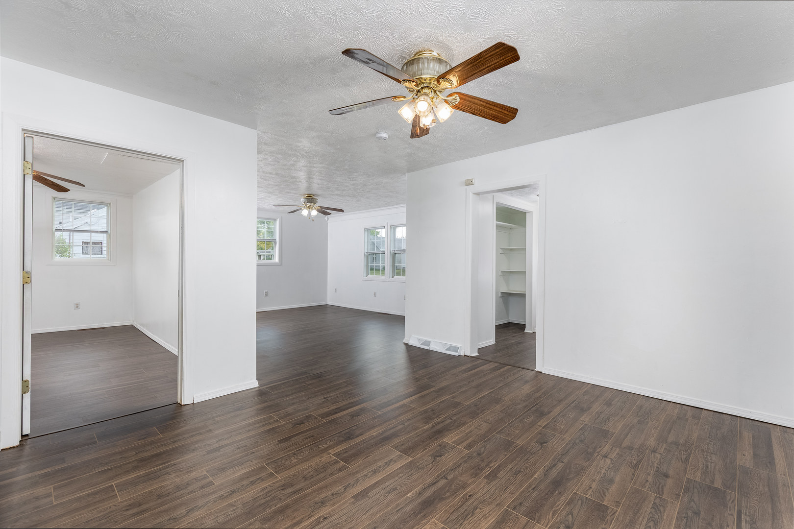 401 South 5th Avenue Streator, IL 61364 - Photo 10 of 17 an empty room with wooden floor chandelier fan and windows