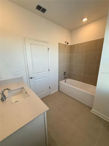 a bathroom with a tub a sink and a shower