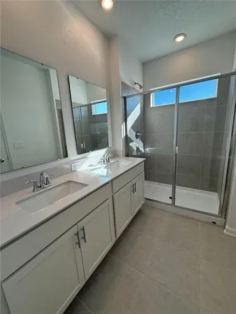 a spacious bathroom with double sink and mirror