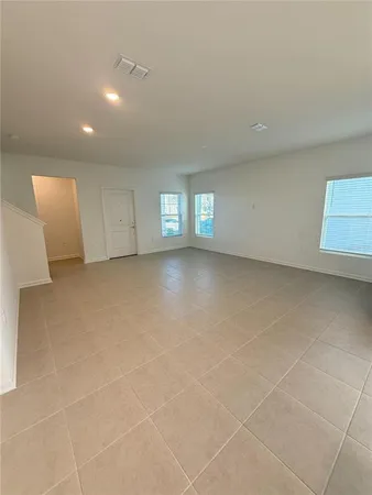 a view of an empty room with windows and a fireplace