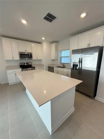 a kitchen with stainless steel appliances a refrigerator sink and microwave