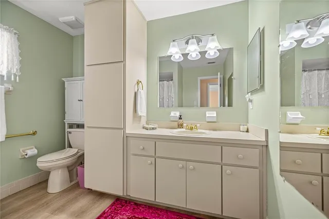 a bathroom with a sink a toilet a large mirror and shower