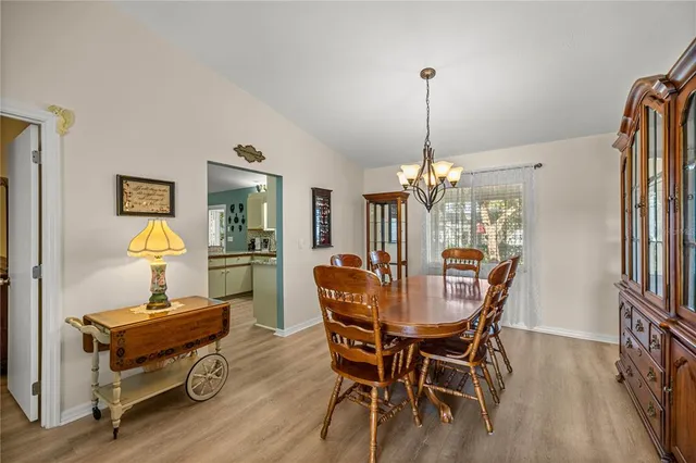 a dining room with furniture a chandelier and wooden floor