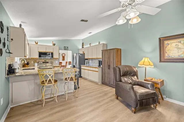 a living room with furniture a fireplace and kitchen view