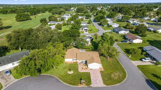 an aerial view of residential houses with outdoor space and trees
