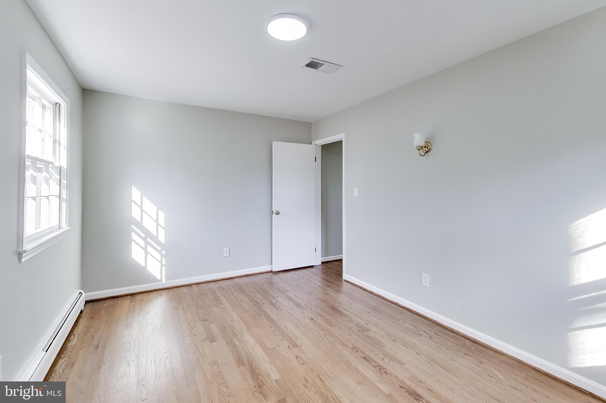 4007 Harrison Road Beltsville, MD 20705 - Photo 25 of 49 an empty room with wooden floor and windows